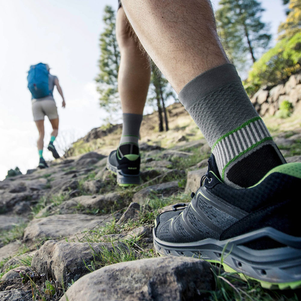 Wandelaars met grijze trekking sokken lopen een Mountain High Zoom op de sokken