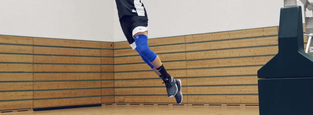 Basketbalspeler in de sprong is het dragen van een NBA knie mouw Mavericks