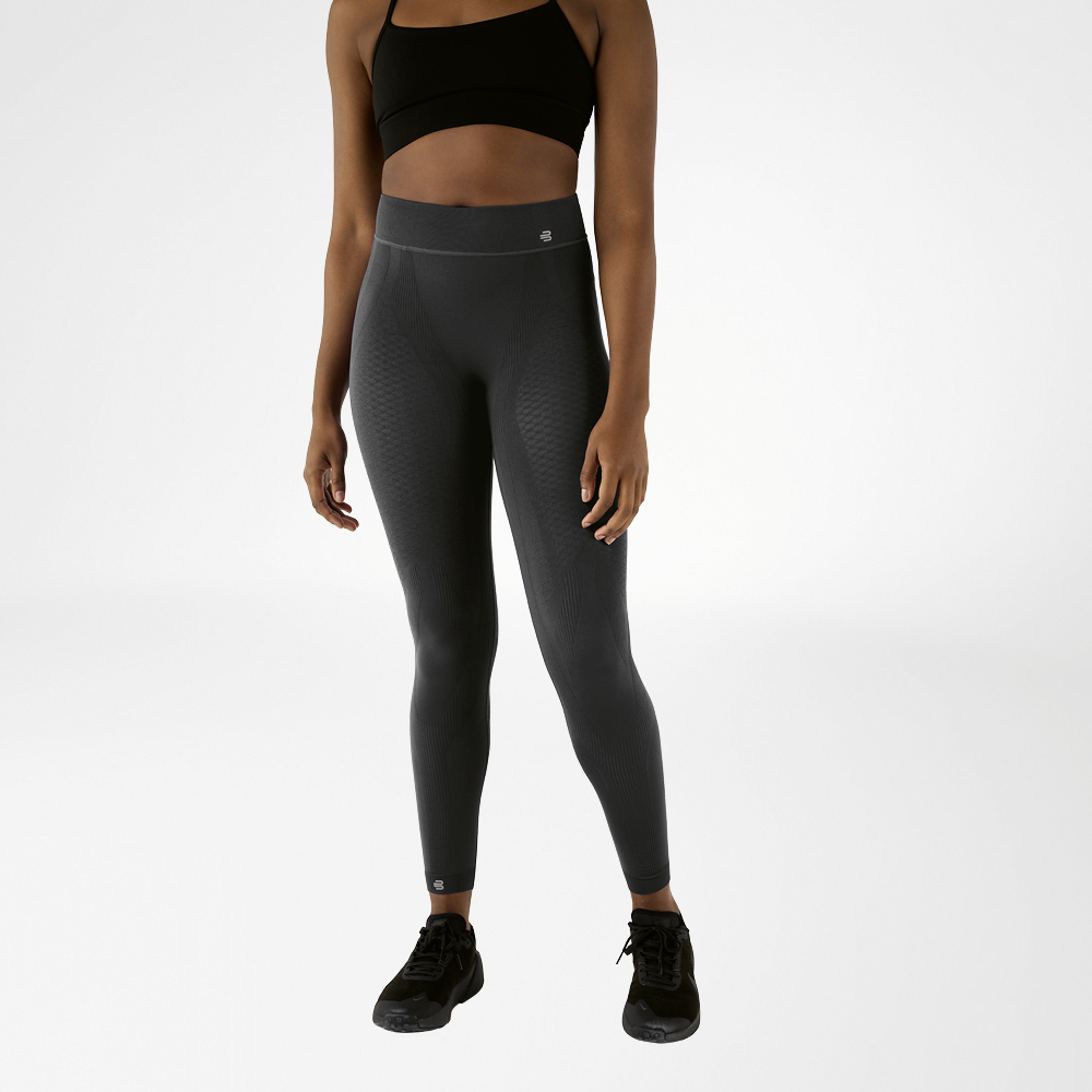 Vrouw in zwarte sportbeha en antracietkleurige enkellange compressieshort