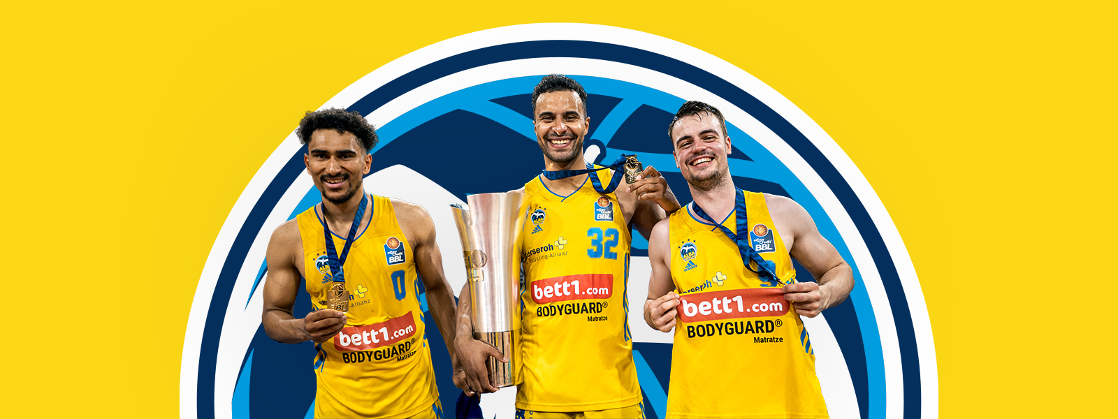 Drie spelers uit Alba Berlin met een trofee voor een geel gebied met het Alba Berlin -logo