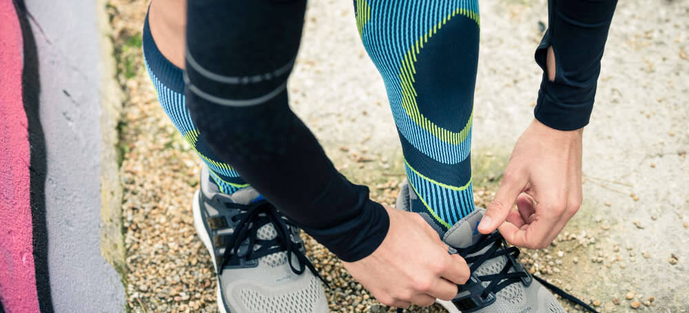 Man met grijsblauwe loopsokken sokken zijn hardloopschoenen