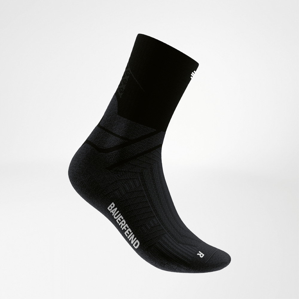Zijaanzicht van een zwarte midcut hardloopsok van Bauerfeind met contrasterend logo en ergonomische pasvorm. Ontworpen voor stabiliteit en grip bij snelle runs, met een mix van performance en stijl.