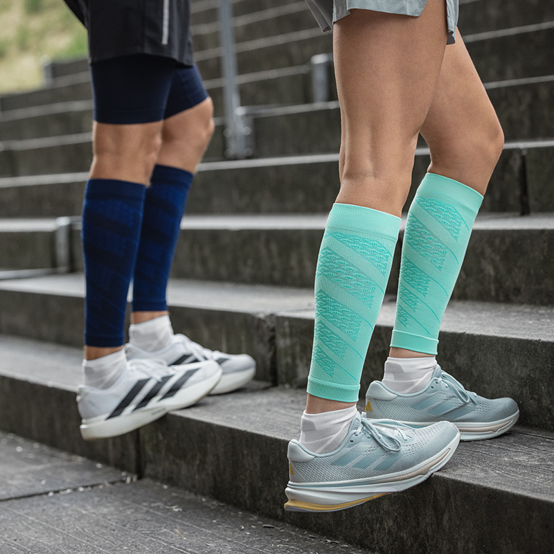 RUN PRESTATIES Compressiesokken Pink Close -up van kleurrijke lopende sokken op het lichaam in een stedelijke omgeving