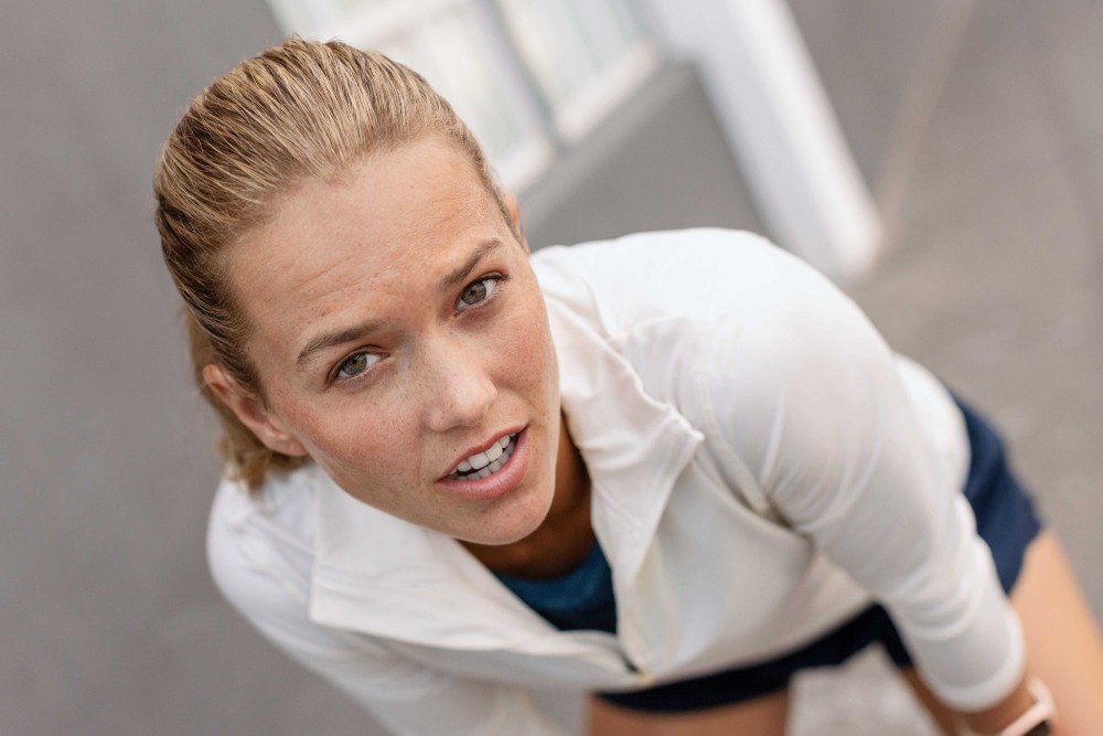 Wil je een marathon uitvoeren? Denk dan aan een paar punten Blonde vrouw met een witte sporttrui kijkt rechtstreeks in de camera