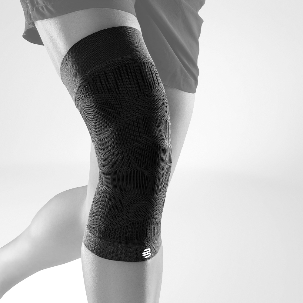 Knie mouw zwart vooraanzicht raar Volledig uitzicht op de zwarte kniehoestjes op een gestileerd grijs been