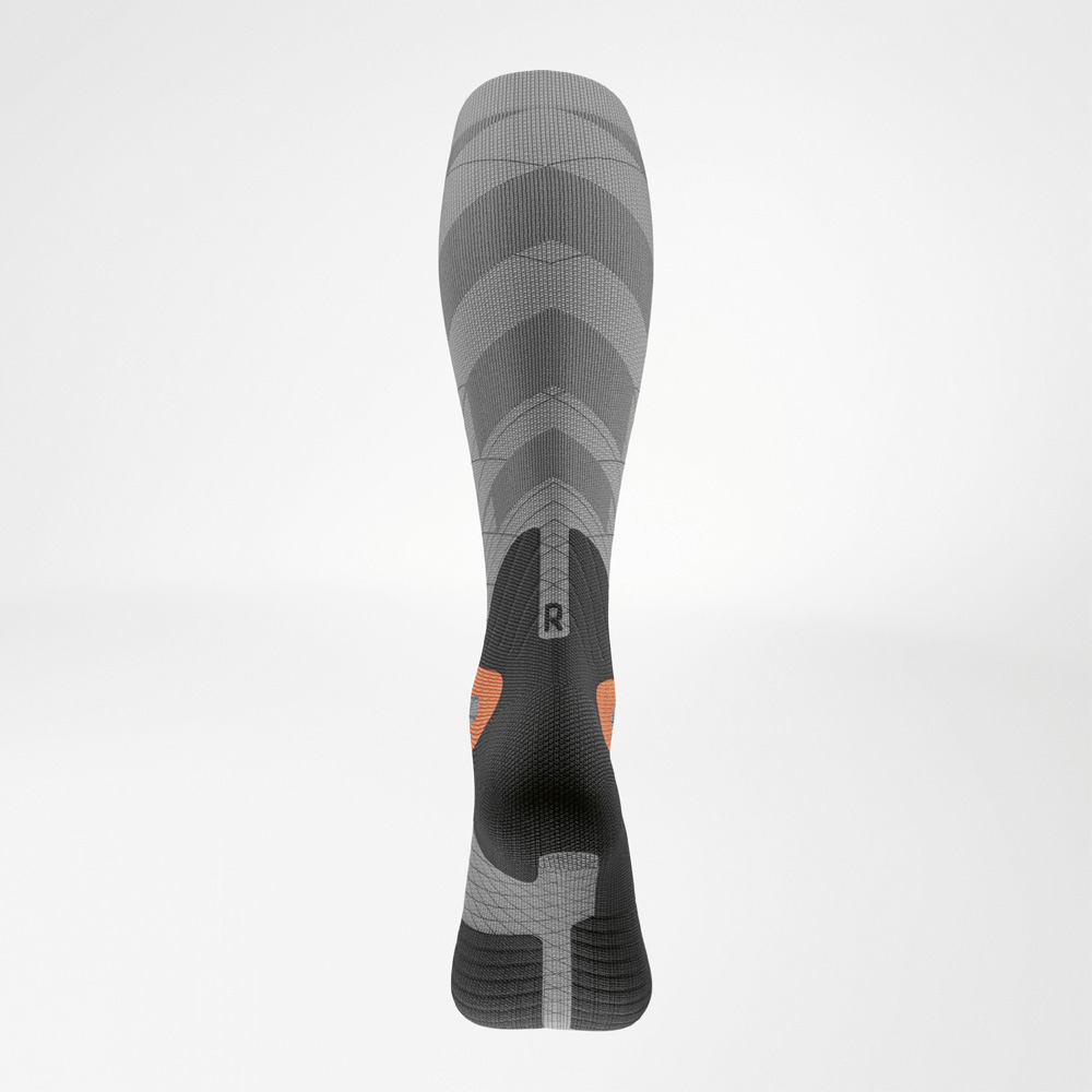 Achteraanzicht van de skisok met compressie voor dames, met stabiliserende schachtstructuur en anatomische rechts/links-aanduiding.
