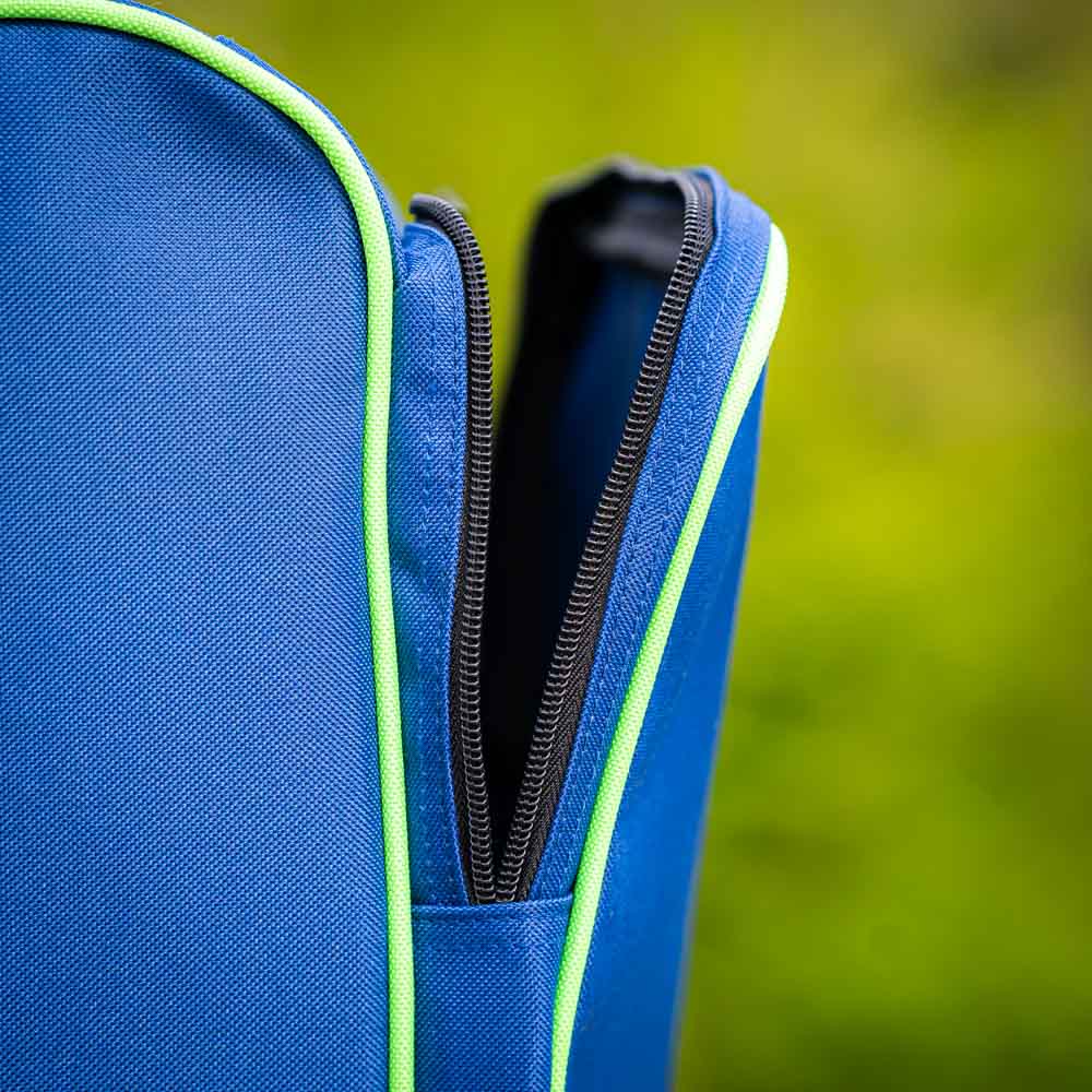 Close-up Ritssluiting Bauerfeind Sports Skitas Close-up van de ritssluiting van de Bauerfeind Sports skitas. De zwarte ritssluiting is gedeeltelijk open en omkaderd door een groene rand. De wazige achtergrond toont groen, wat wijst op een buitenomgeving.