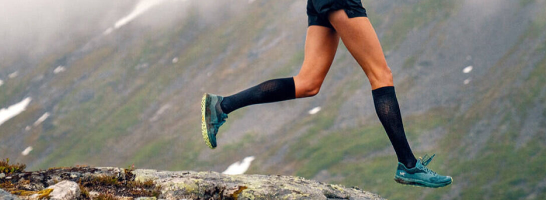 Compressiesokken sport ultralicht zwart hardlopen Langer De zwarte lichte compressiesokken en rennen en rennen op een pad voor een berg