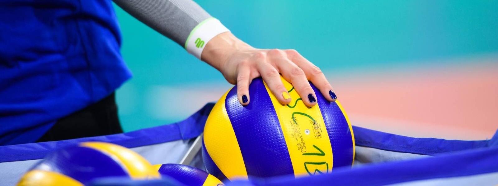 ARM MOEVEN IN VOLLEYBALL Volleybalspeler met witte arm mouwen pak een volleybal