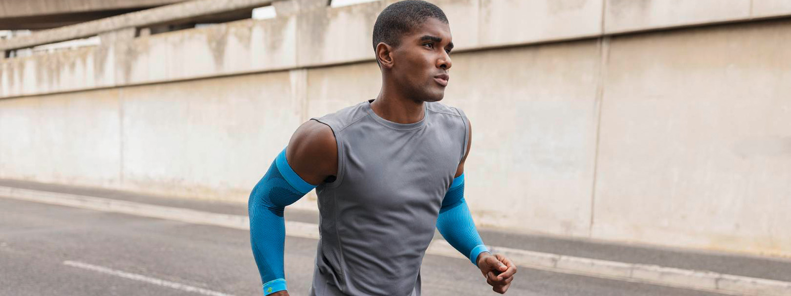 Sportcompressie mouwen arm Rivera rennen Man jogt in de stad en heeft blauwe compressiearmmouwen