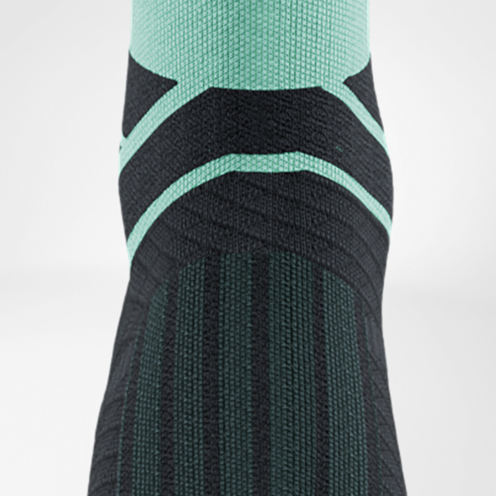 Close-up van de Run Performance Midcut Socks in mint met zwart patroon. Te zien is het wreefgebied en de overgang naar de enkel, waarbij de nauwsluitende breistructuur steun en ademend vermogen biedt.